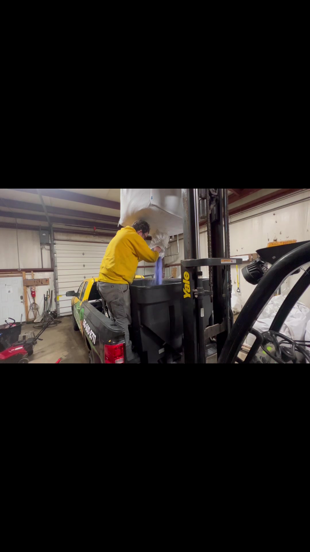 Hopper nozzle filling a spreader from a Purple Power super sack